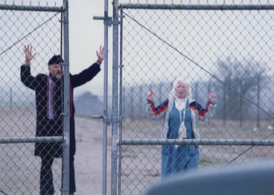 Oblate Fr. Carl Kabat and fellow protester Carol Carson walk out of the fence surrounding nuclear missile silo in Missouri during a Good Friday protest April 17, 1992. (NCR file photo)