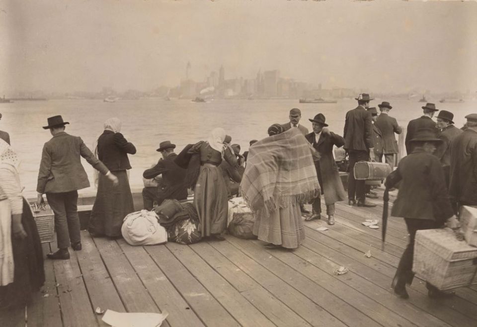 Immigrants wait at Ellis Island to be transferred Oct. 30, 1912. (PBS/ Library of Congress)