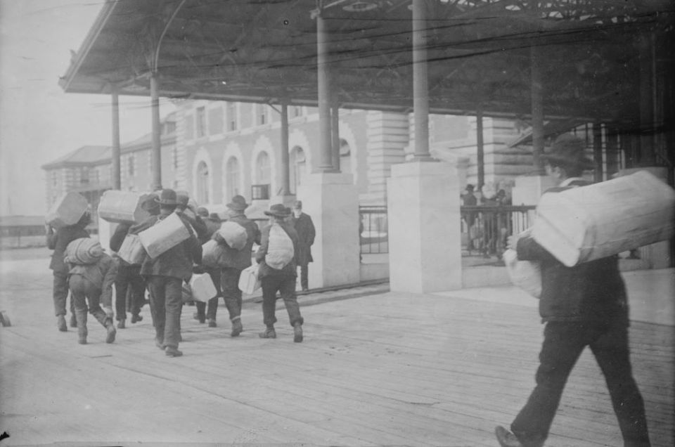 Immigrants carry luggage, Ellis Island, New York. (PBS/Library of Congress)