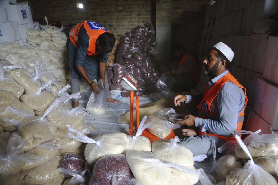 Volunteers from an Islamic charity group prepare food packets to be sent into flood-hit areas, in Peshawar, Pakistan, Aug. 26, 2022. (AP Photo/Muhammad Sajjad)