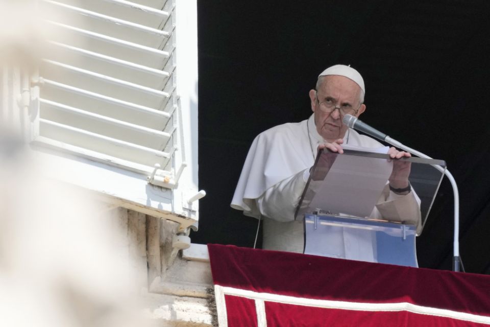 Pope Francis reads his message during the Angelus noon prayer July 18 from the window of his studio overlooking St. Peter's Square at the Vatican. (AP/Alessandra Tarantino)