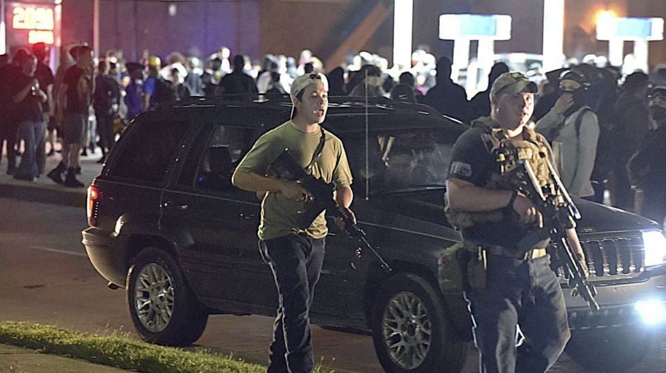 Kyle Rittenhouse, left, walks along Sheridan Road in Kenosha, Wisconsin, Tuesday, Aug. 25, 2020, with another armed civilian. (Adam Rogan/The Journal Times via AP)