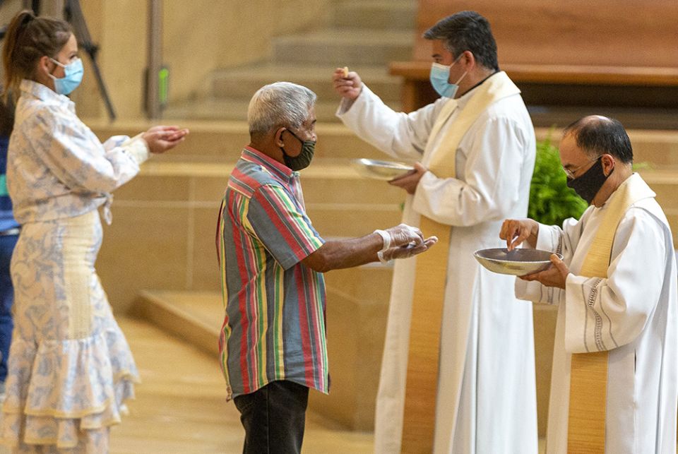 The faithful wear masks and some wear gloves as they receive Communion at the first English Mass with faithful present at the Cathedral of Our Lady of the Angels in downtown Los Angeles, June 7, 2020. (AP)
