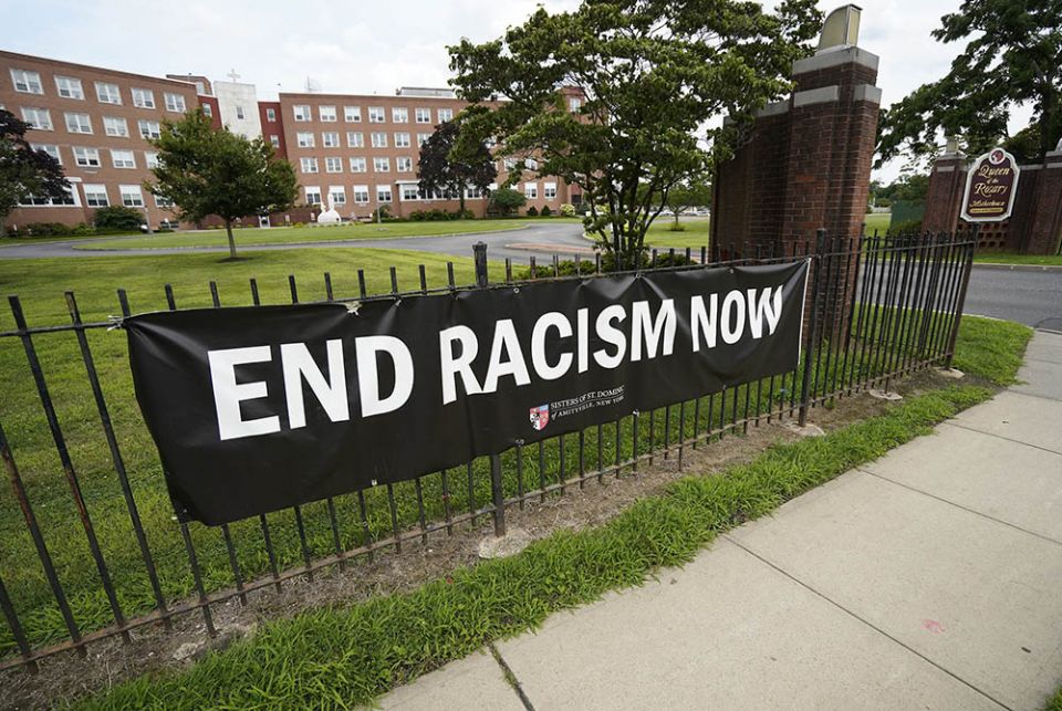 An anti-racism banner created by the Sisters of St. Dominic of Amityville, New York, is seen July 22 near the main gate to the religious community's motherhouse. (CNS/Gregory A. Shemitz)
