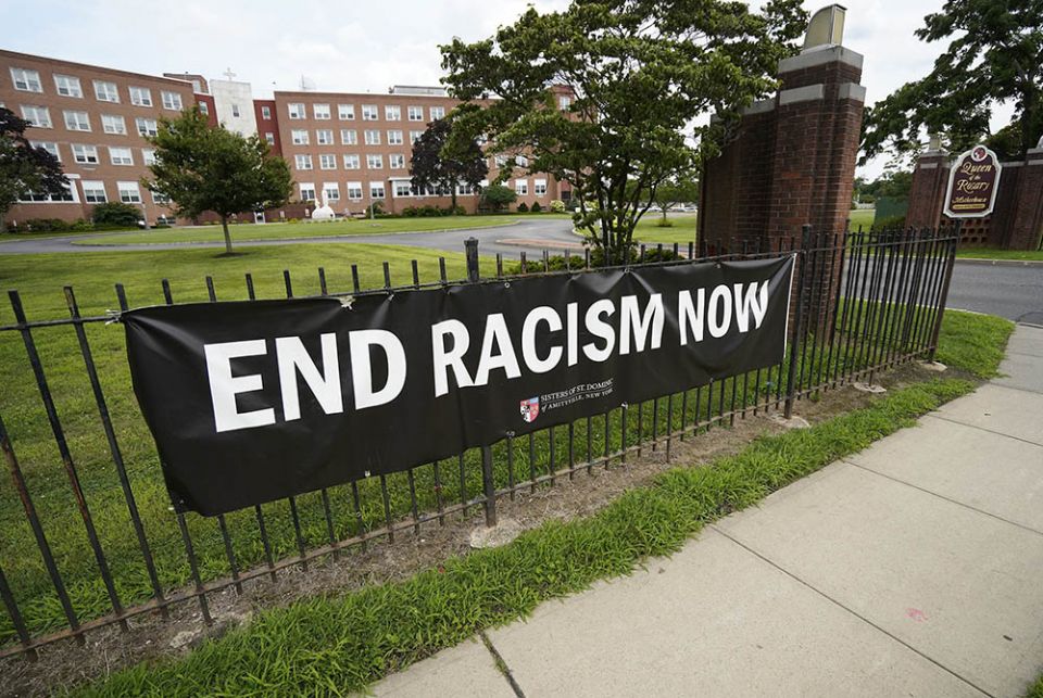 Anti racism banner An anti-racism banner created by the Sisters of St. Dominic of Amityville, New York, is seen July 22 near the main gate to the religious community's motherhouse. (CNS/Gregory A. Shemitz)