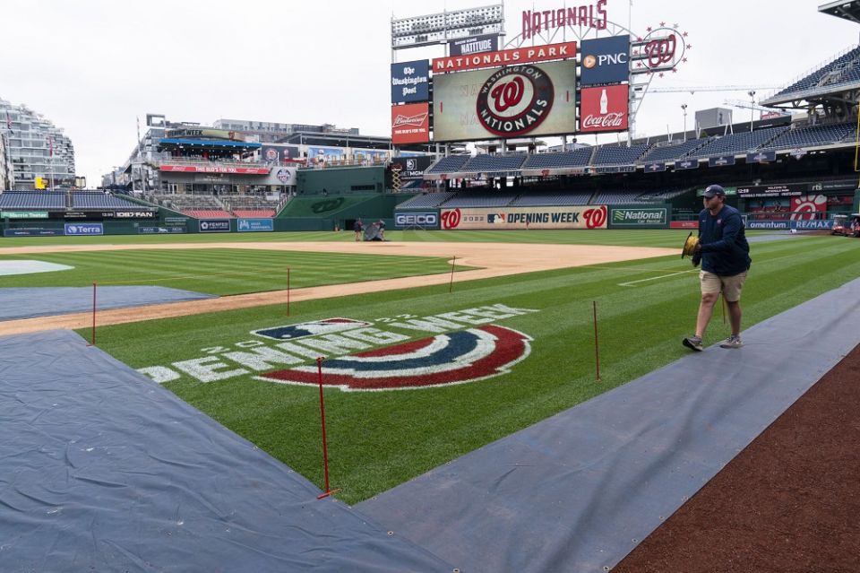 A member of the grounds crew ropes off the on-field logo before baseball workouts at Nationals Park, April 6, in Washington.