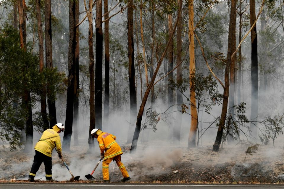 Firefighters contain a bushfire along a highway near Ulladulla, Australia, Jan. 5. (CNS/Reuters/AAP/Dean Lewins)