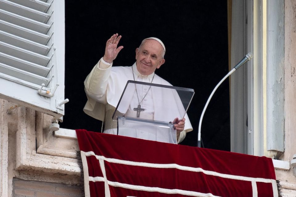 Pope Francis greets the crowd as he leads the Angelus from the window of his studio overlooking St. Peter's Square at the Vatican Oct. 11. (CNS/Vatican Media)