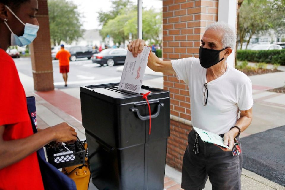 A man in Orlando, Florida, casts his mail-in ballot Oct. 19, as early voting begins ahead of the November 3 election. (CNS/Reuters/Octavio Jones)
