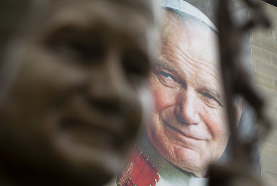 A banner of St. John Paul II is seen behind a sculpture of him May 16, 2018, at the St. John Paul II National Shrine in Washington. (CNS photo/Tyler Orsburn)