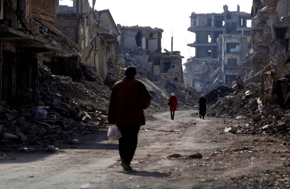 People walk past damaged buildings at the Yarmouk Palestinian refugee camp on the outskirts of Damascus, Syria Dec. 2. (CNS/Reuters/Omar Sanadiki) People walk past damaged buildings at the Yarmouk Palestinian refugee camp on the outskirts of Damascus, Syria Dec. 2. (CNS/Reuters/Omar Sanadiki)