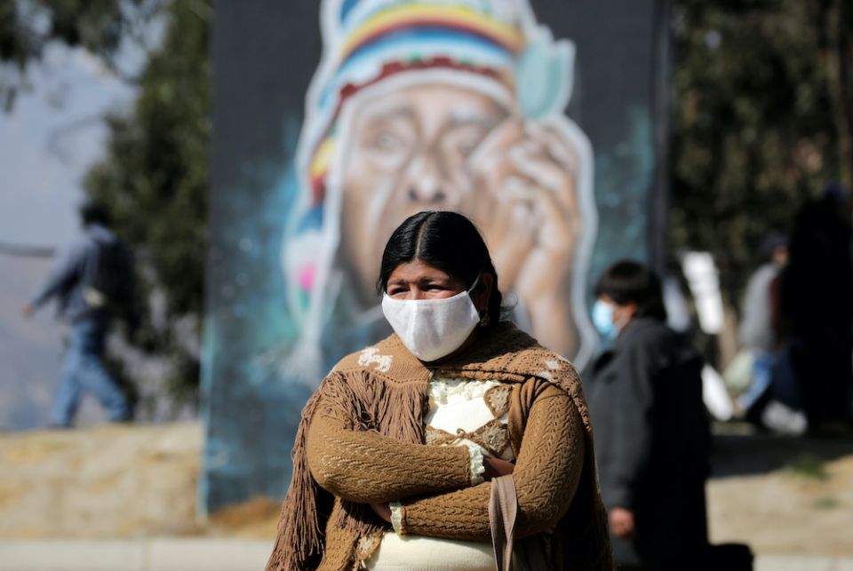 An Aymara woman wearing a protective mask stands at the blockade point set up by supporters of former President Evo Morales in El Alto, Bolivia, Aug. 10, when protesters were demanding quick presidential elections, postponed multiple times due to the COVI