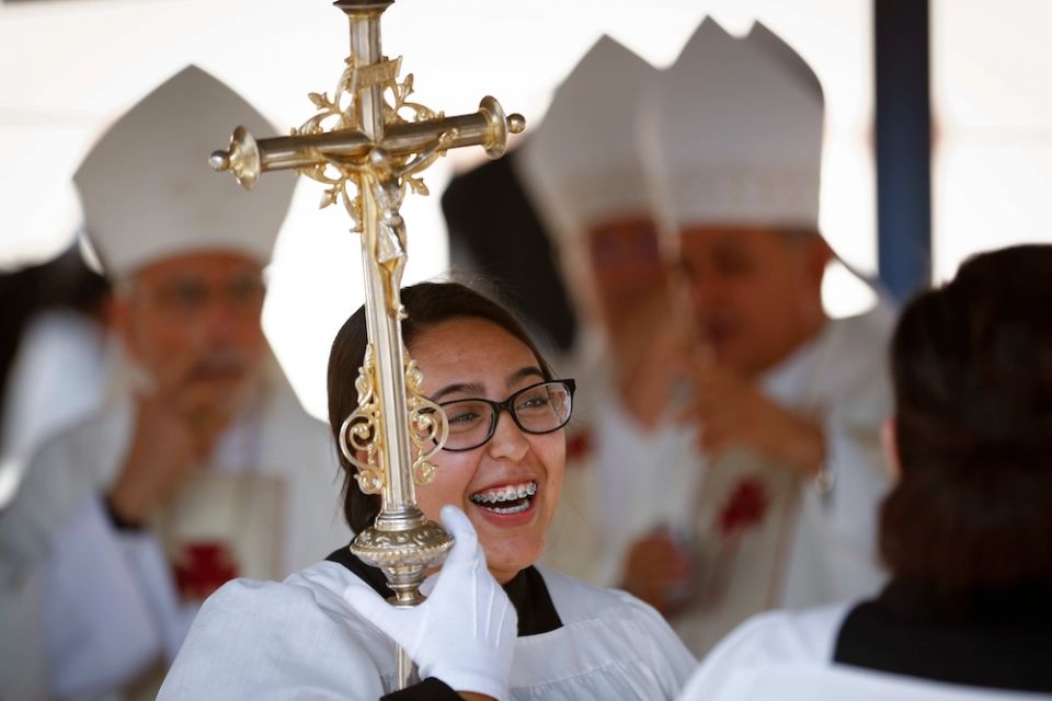 Glenda Lopez smiles as she and other altar servers wait for the start of Mass at the international border in Nogales, Arizona, Oct. 23, 2016. The pope recently changed Vatican law to allow all "lay persons," not just men, to be formally installed as lecto