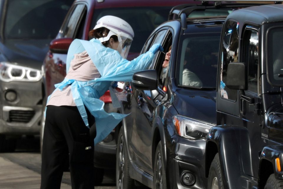 A health care worker in Denver tests people for the coronavirus at a drive-thru testing station March 11, 2020. (CNS/Reuters/Jim Urquhart)