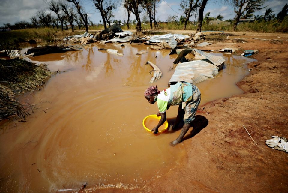 A woman collects water for washing as floodwaters begin to recede in the aftermath of Cyclone Idai near Beira, Mozambique, in March. (CNS/Reuters/Mike Hutchings) A woman collects water for washing as floodwaters begin to recede in the aftermath of Cyclone Idai near Beira, Mozambique, in March. (CNS/Reuters/Mike Hutchings)