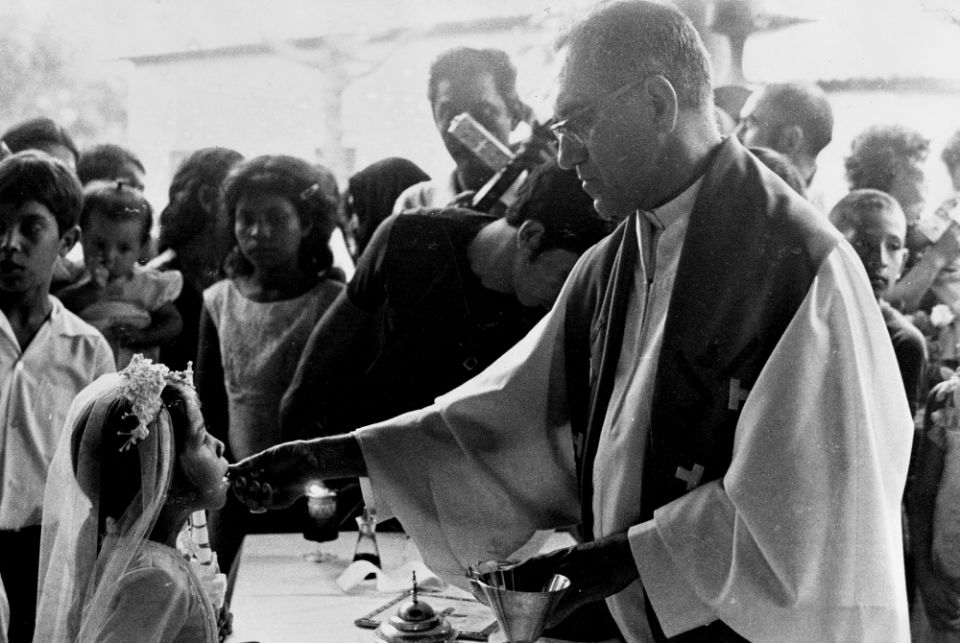 Archbishop Óscar Romero distributes Communion during a confirmation Mass in Ateos, El Salvador, in September 1979. (NCR photo/June Carolyn Erlick)