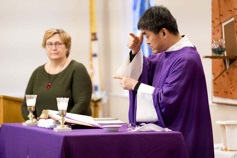 Fr. Min Seo Park signs the Mass in American Sign Language on Ash Wednesday, Feb. 17, 2021. To his left is Laureen Lynch-Ryan, the Washington Archdiocese's coordinator for deaf ministry. (Joe Portolano)