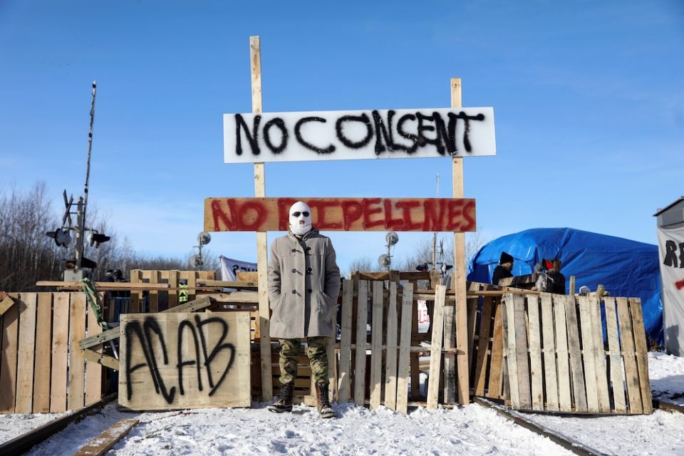 A supporter of the indigenous Wet'suwet'en Nation's hereditary chiefs stands at a railway blockade during a pipeline protest in Edmonton, Alberta, Canada in February 2020. (CNS photo/Codie McLachlan, Reuters)