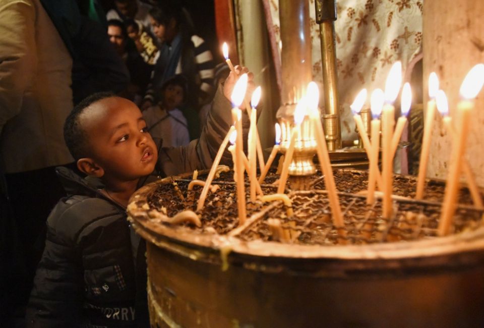 An Ethiopian boy lights a candle in the grotto in the Church of Nativity in Bethlehem, West Bank, Dec. 15, 2018. The church is built on the site believed to be where Jesus was born. (CNS/Debbie Hill)