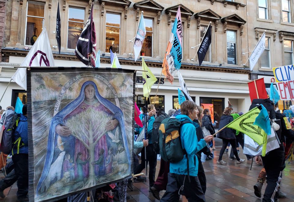 A banner showing Mary embracing a tree is seen in the procession of "climate pilgrims" arriving in Glasgow, Scotland, for the U.N. climate conference known as COP26. (NCR/Brian Roewe) 