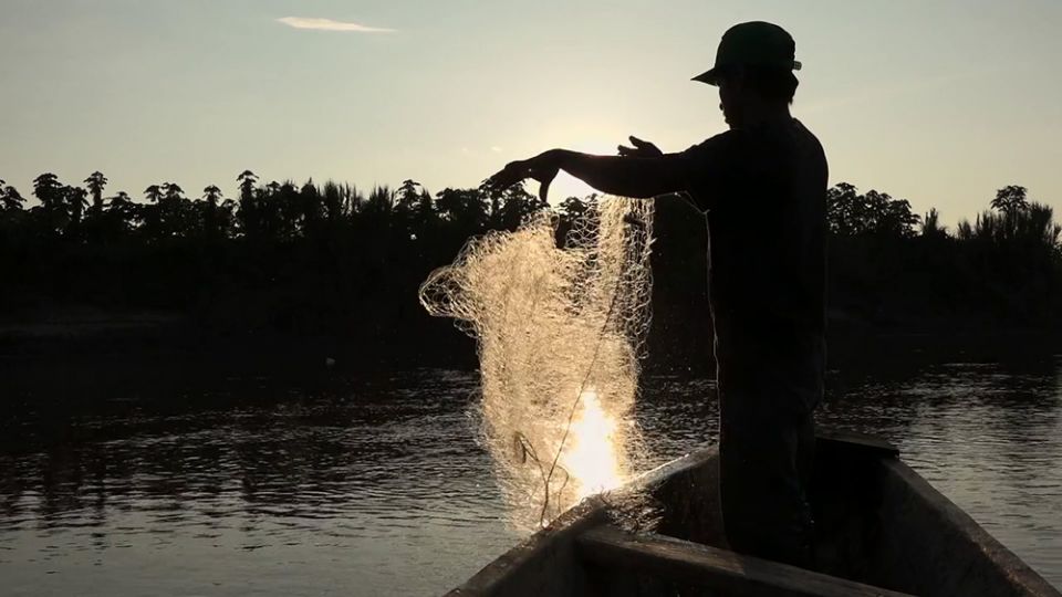 A man tends his fishing net at sundown along the Marañón River in Peru. (Quisca Producciones/M. Araoz)
