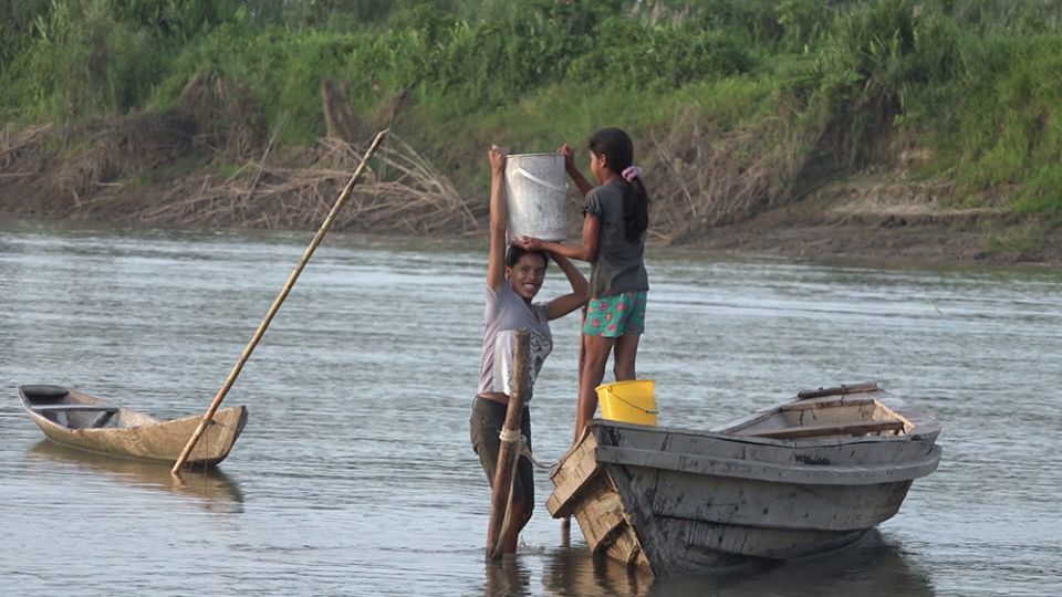 Two young women load buckets of water into their canoe on the Marañón River in Peru. (Quisca Producciones)