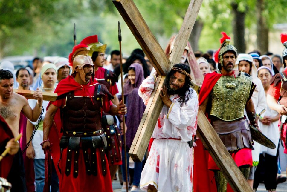 A man portraying Jesus carries a cross down a neighborhood street during a live re-enactment of the Stations of the Cross outside All Saints Catholic Church in Houston on Good Friday, April 14, 2017. (CNS/Catholic Herald/James Ramos)