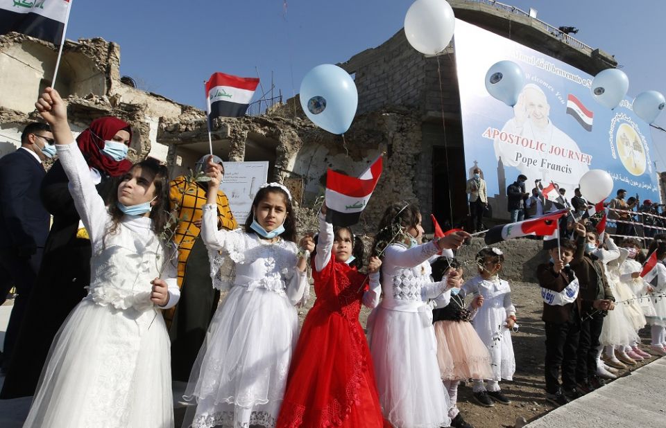Children wave Iraqi flags before Pope Francis' arrival for a memorial prayer for the victims of the war at Hosh al-Bieaa (church square) in Mosul, Iraq, March 7, 2021. (Paul Haring/CNS) Iraqi girls wave flags