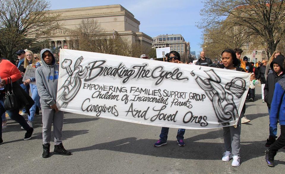 Young activists carry a banner for children of incarcerated parents during the March for Our Lives in Washington, D.C., on March 24, 2018. (Wikimedia Commons/Ziggyfan23) Young activists carry a banner for children of incarcerated parents during the March for Our Lives in Washington, D.C., on March 24, 2018. (Wikimedia Commons/Ziggyfan23)