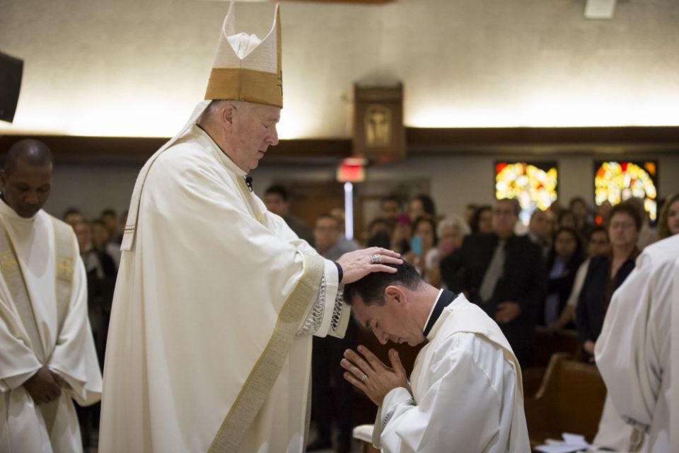 San Diego Bishop Robert McElroy lays hands on Jesuit ordinand Alejandro Báez during the June 9 ordination Mass at Our Lady of Mount Carmel Parish in San Ysidro, California, near the U.S.-Mexico border. (Jon Rou)