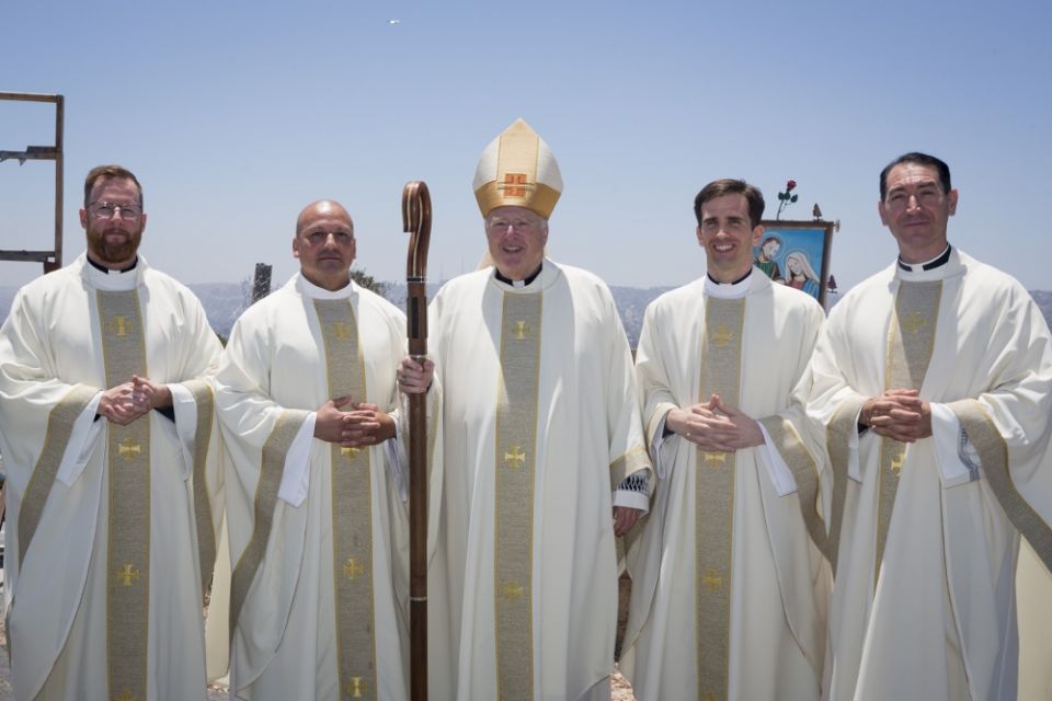 Bishop Robert McElroy stands with, from left, newly ordained Jesuit Frs. J.T. Tanner, Elías Puentes, Alejandro Báez and Thomas Flowers. (Jon Rou)
