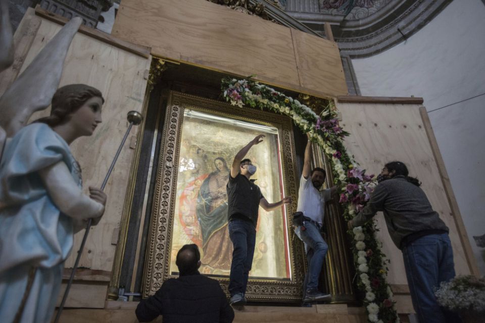 Parishioners remove a portion of a flower arch surrounding a painted copy portraying the Assumption of the Virgin inside the quake-damaged Our Lady of the Angels Catholic Church, in Mexico City Aug. 7. (AP/Ginnette Riquelme)