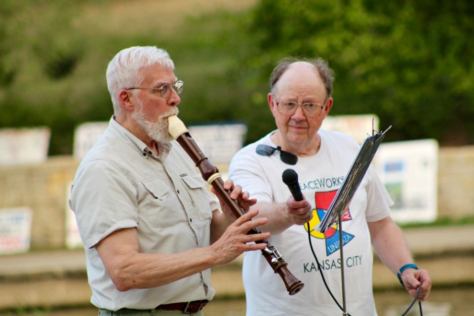 Flutist Michael McGrath plays " 'Tis the Gift to Be Simple" while Henry Stoever holds the microphone the Hiroshima/Nagasaki Remembrance memorial Aug. 5 in Kansas City, Missouri. (Jim Hannah)