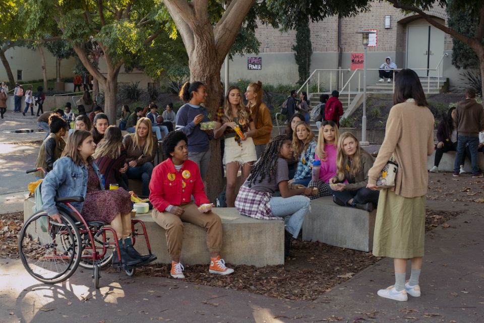Teens sitting outside in high school courtyard, scene from movie "Moxie"