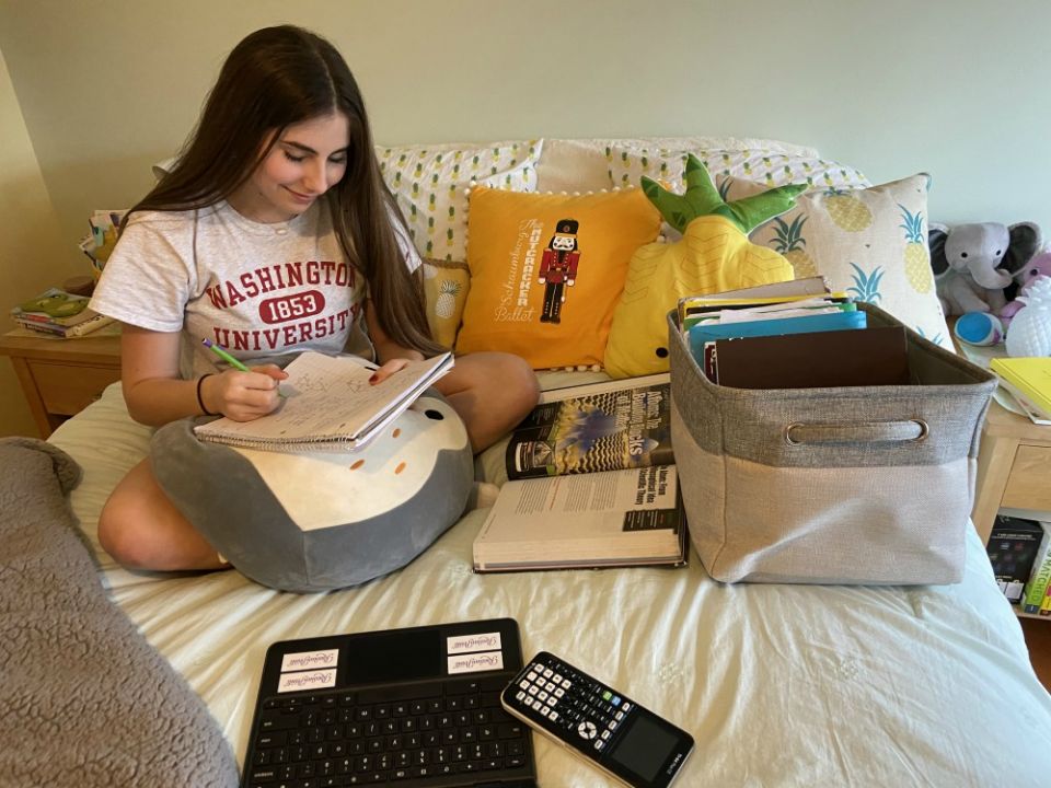 Nina Borkowski, a sophomore at Carmel Catholic High School in Mundelein, Illinois, works on class assignments on top of her bed. (Gina Borkowski)