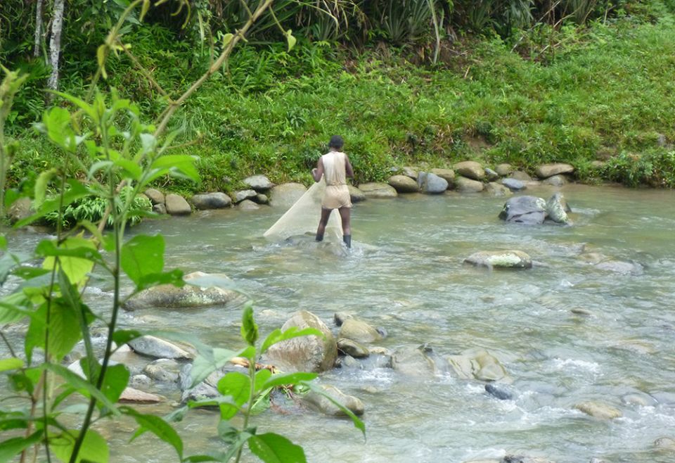 A woman fishes in San Marino, Chocó. The region in northwest Colombia is home to many Indigenous and Afro-Colombian communities that live along the length of the Atrato River. (Courtesy of ABColombia)