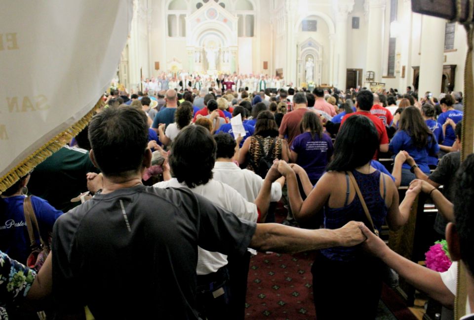 Joining hands, an overflow crowd prays for migrants and refugees during a July 20 evening service at St. Patrick Cathedral in El Paso, Texas. (MVO Photography/Lulu Olvera)