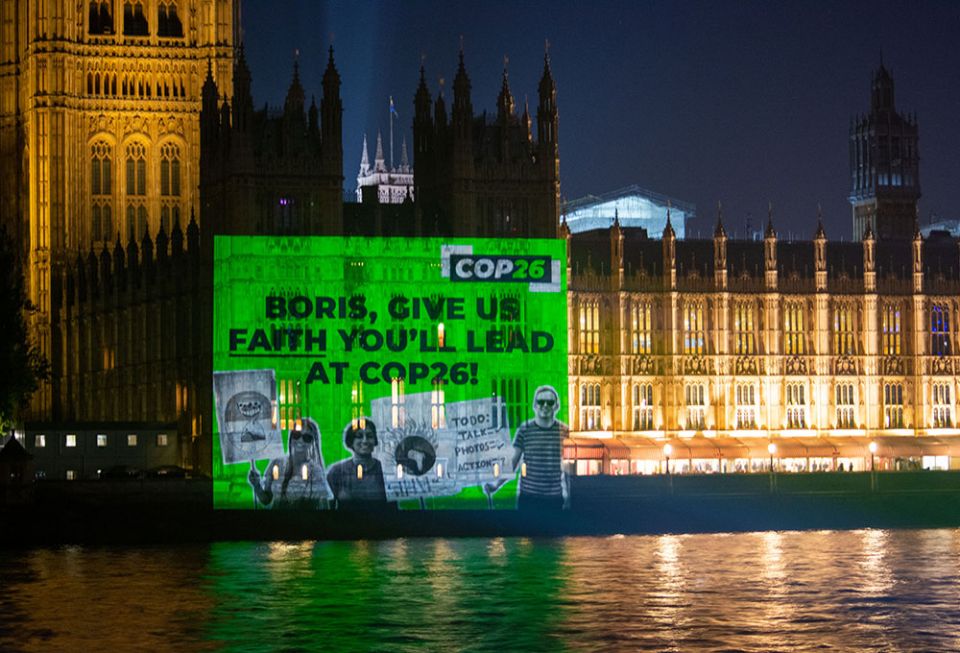 An image projected onto Parliament in London Oct. 25 urges British Prime Minister Boris Johnson to show leadership at the U.N. climate conference, COP26, which opens Oct. 31 in Glasgow, Scotland.