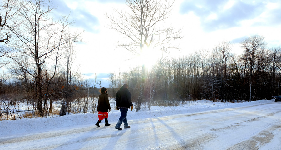Taysha Martineau and Jason Goward walk down road between Camp Migizi and one of the Enbridge Line 3 work sites on the Fond du lac reservation. (Photo by Mary Annette Pember, Indian Country Today)