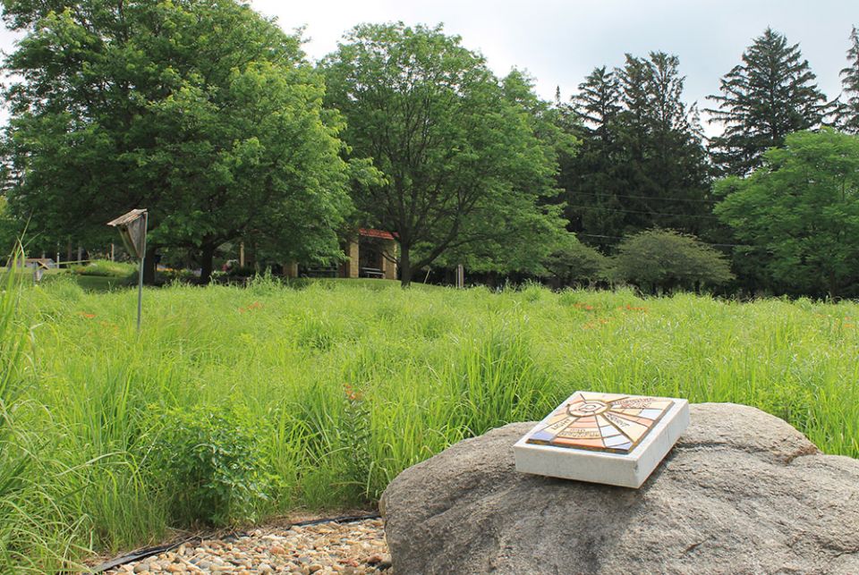 A tablet rests on a rock in a meadow that is part of the conservation easement of the Sisters of St. Francis of Rochester, Minnesota. (EarthBeat photo/Brian Roewe)