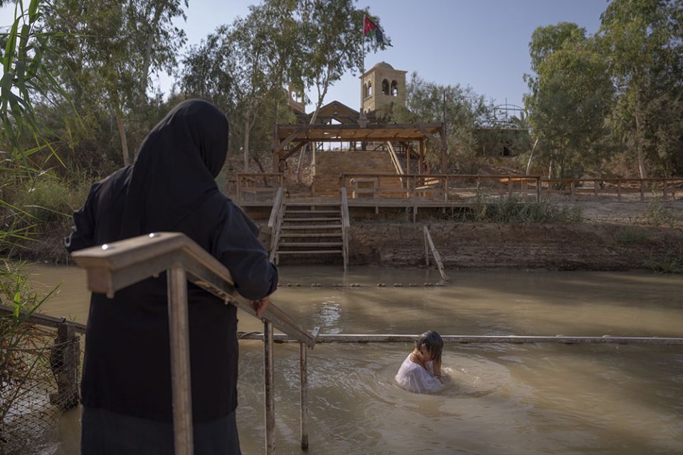 Olga Bokkas, a visitor from Connecticut, immerses herself in the waters of the Jordan River at the Qasr al-Yahud baptismal site, near the West Bank town of Jericho July 31. The river’s dwindling waters are sluggish and a dull brownish green in this area.