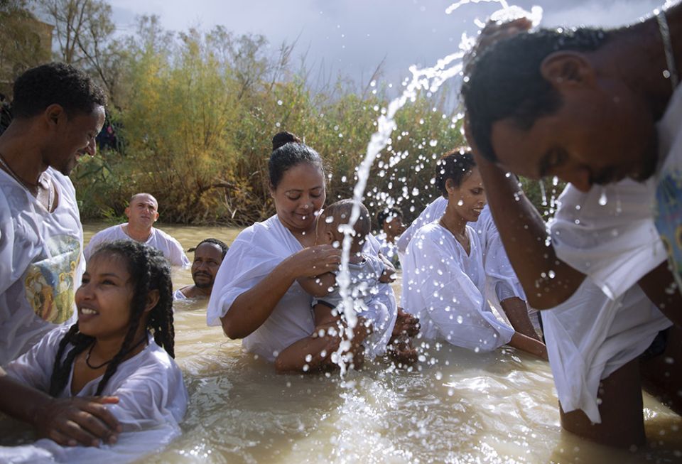 Members of the Eritrean and Ethiopian Christian Orthodox community from Tel Aviv participate in a baptismal ceremony in the waters of the Jordan River as part of the Orthodox feast of the Epiphany at the Qasr al-Yahud baptismal site in 2018.