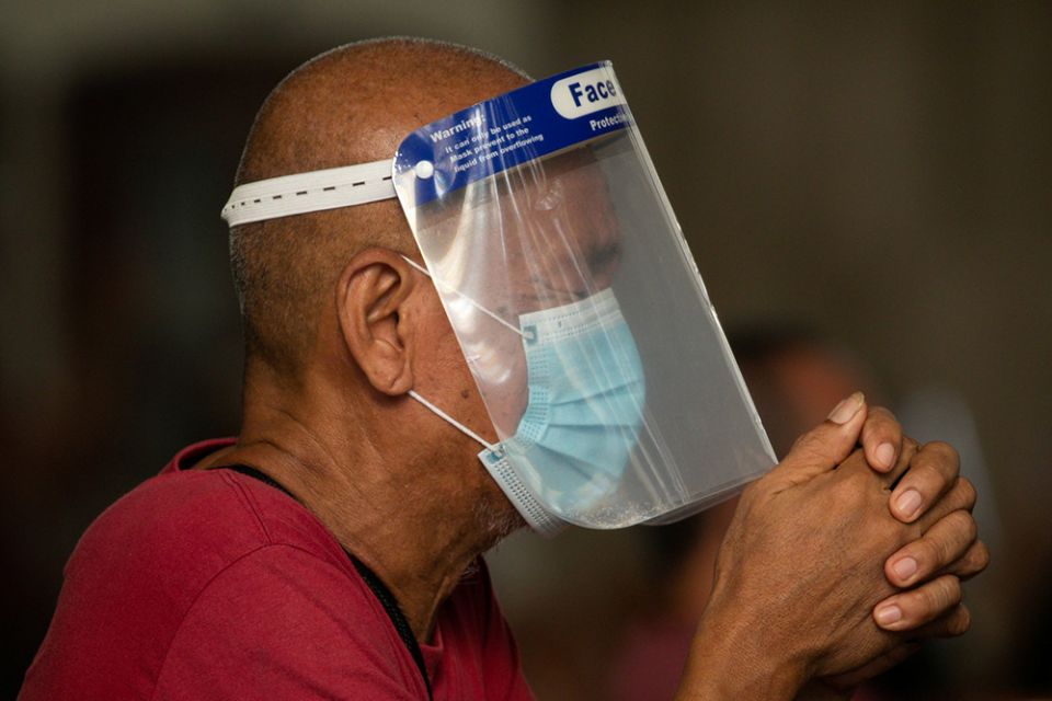 A man wearing a protective mask and face shield prays inside the Minor Basilica of the Black Nazarene in Manila, Philippines, Oct. 2, 2020, during the COVID-19 pandemic. (CNS/Reuters/Eloisa Lopez) A man wearing a protective mask and face shield prays inside the Minor Basilica of the Black Nazarene in Manila, Philippines, Oct. 2, 2020, during the COVID-19 pandemic. (CNS/Reuters/Eloisa Lopez)