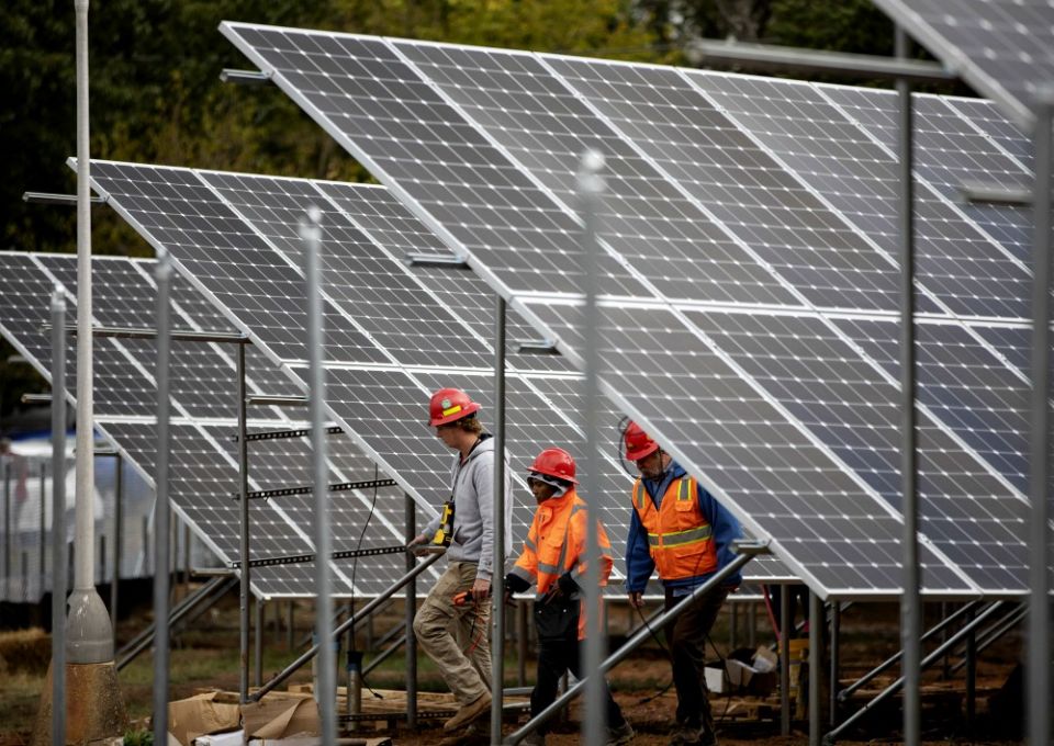 Workers in Washington are seen near solar panels Oct. 17, 2019, on the property of Catholic Charities of the Washington Archdiocese. (CNS/Catholic Standard/Andrew Biraj)