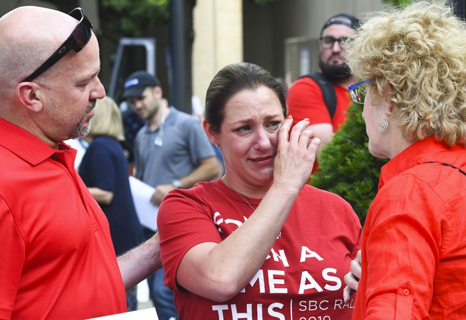 In this June 11, 2019 file photo, Jules Woodson, center is comforted by her boyfriend Ben Smith, left, and Christa Brown during a demonstration outside the Southern Baptist Convention's annual meeting in Birmingham, Alabama. (AP photo/Julie Bennett, file) In this June 11, 2019 file photo, Jules Woodson, center is comforted by her boyfriend Ben Smith, left, and Christa Brown during a demonstration outside the Southern Baptist Convention's annual meeting in Birmingham, Alabama. (AP photo/Julie Bennett, file)
