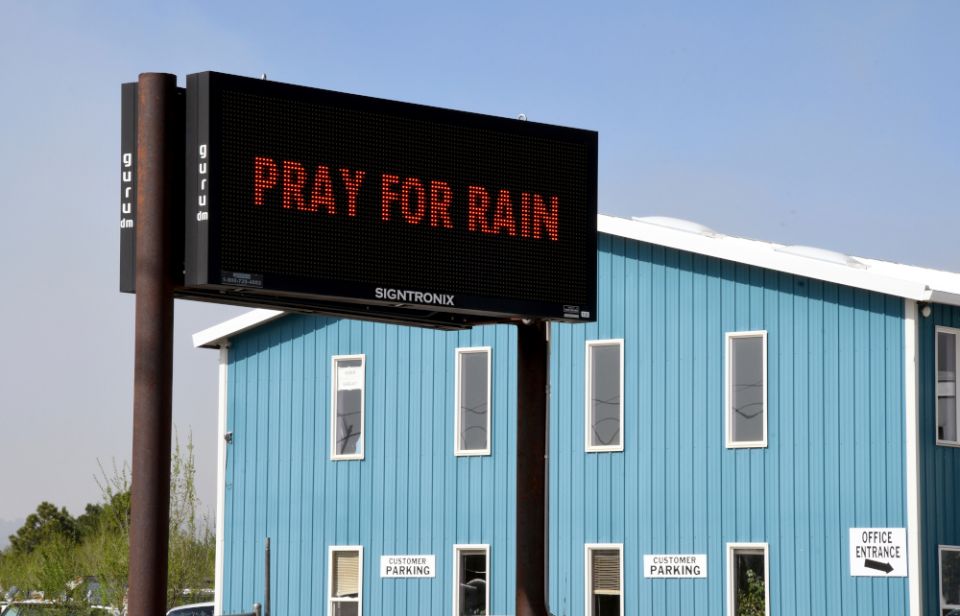 An electronic sign outside a business in Las Vegas, New Mexico, on Wednesday, May 4, 2022, asks passersby to "Pray for Rain" as a massive wildfire spreads in the nearby mountains. (AP/Thomas Peipert)
