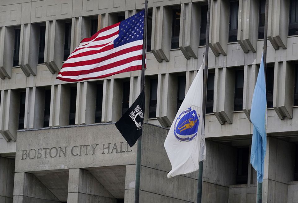 The American flag, the Commonwealth of Massachusetts flag, and the City of Boston flag, from left, fly outside Boston City Hall May 2. (AP/Charles Krupa)