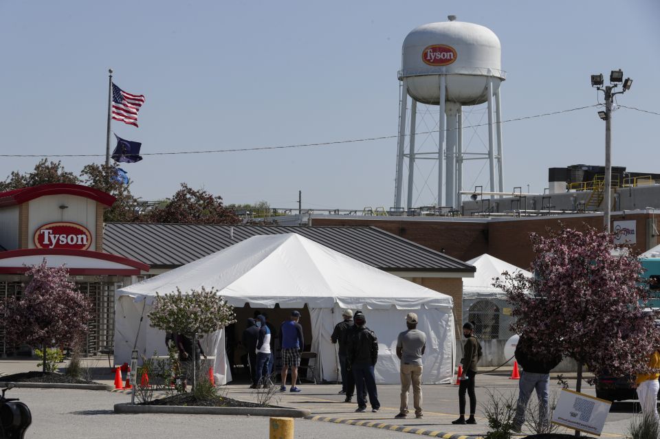 Workers wait in line to enter the Tyson Foods pork processing plant in Logansport, Ind., in this May 7, 2020 file photo. (AP/Michael Conroy)