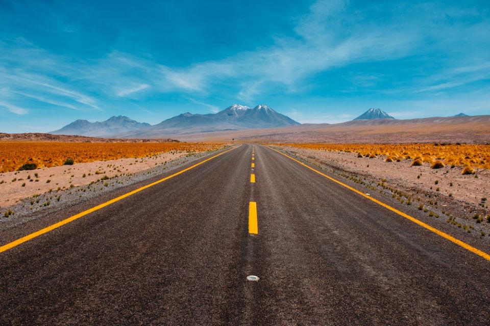 Image of a road in the desert facing mountains (Unsplash/Diego Jimenez)