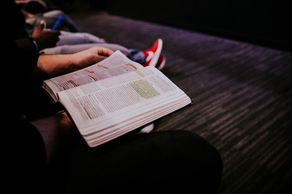 But in late summer, as restrictions on outdoor gatherings in Berkeley relaxed a bit, a small group began to meet, masked and distanced, in a nearby park to read and reflect on Scripture, and pray. (Unsplash/Hannah Busing) Bible page opened to Matthew, with highlights, in the hand of a person sitting on a park bench